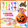 A set of five colored spider web toys and Halloween party favors displayed around an orange pumpkin.