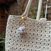 A handcrafted crochet animal keychain featuring a small, fluffy rabbit or chick charm attached to a gold-toned ring.