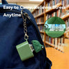 A green duck and frog clicker keychain with an LED light attached to a dark blue backpack.