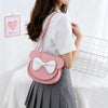 A pink kids' hard shell crossbody bag with mouse ears and a white bow worn by a girl.
