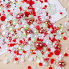 A scatter of mixed resin rhinestone pearls in various colors including red, pink, green, and white on a wooden surface.
