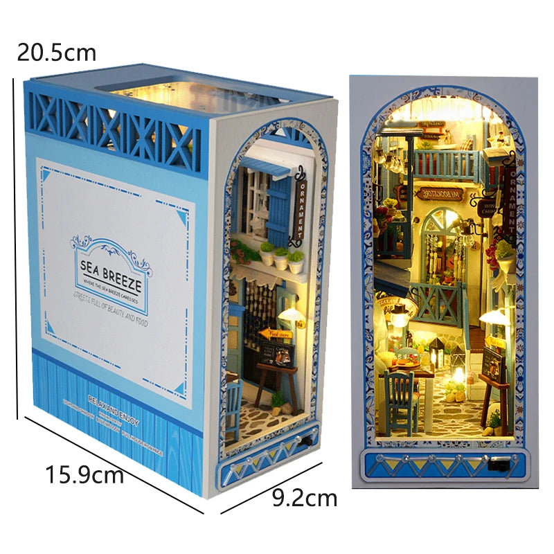 A wooden book nook kit featuring a detailed seaside scene with built-in LED lighting.
