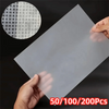 A hand holds a sheet of double-sided diamond painting release paper with a circular pattern visible on the top layer.