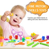 A baby is playing with fine motor skills toys including colorful objects, sorting cups, and tweezers.