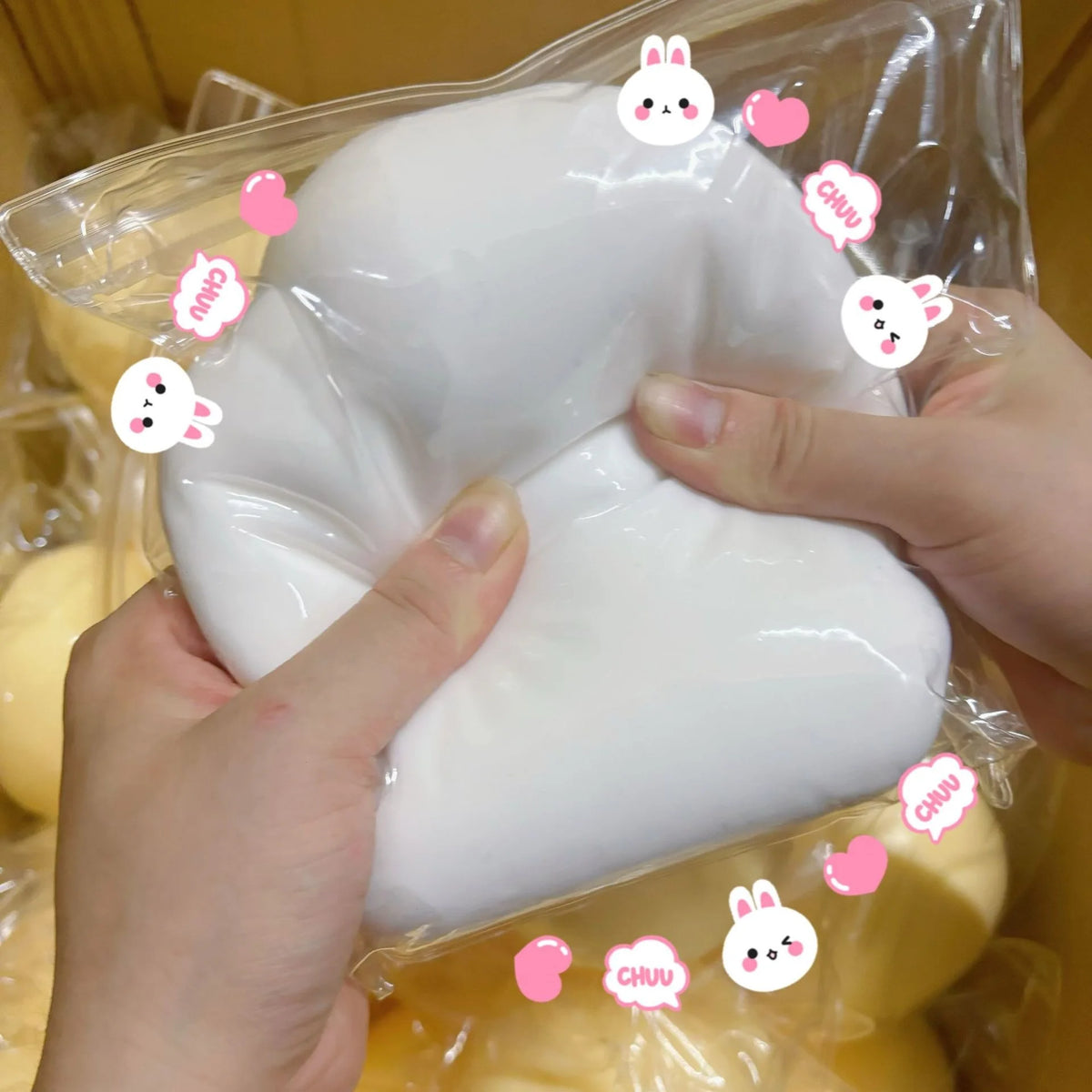 Eine Hand hält einen großen weißen Squishy-Stressball-Fidget-Spielzeug in einem klaren Plastikbeutel.