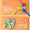 A board game setup showing a player using a cat claw to capture colored cards, with other cards visible.