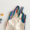 A set of colorful striped kids overalls featuring a white fabric with a raindrop print.