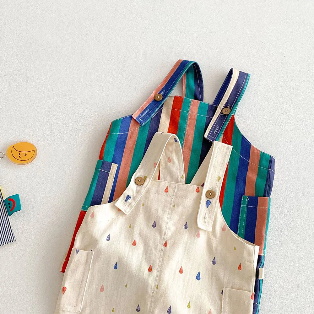 A set of colorful striped kids overalls featuring a white fabric with a raindrop print.