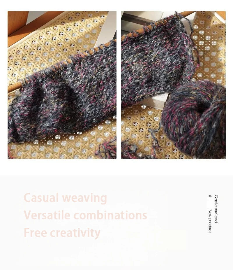 Close-up view of dark gray and pink variegated alpaca blend yarn skeins on a patterned fabric background.