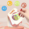 A hand is drawing geometric patterns using a spirograph kit with various colored templates.