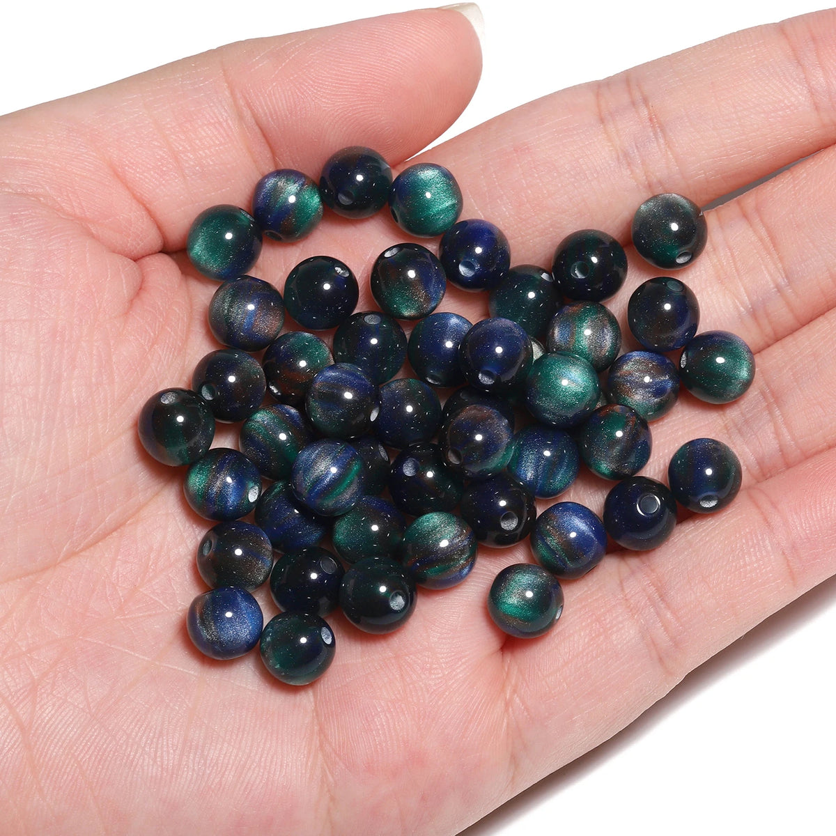 A handful of dark blue and green tiger eye resin beads for jewelry making