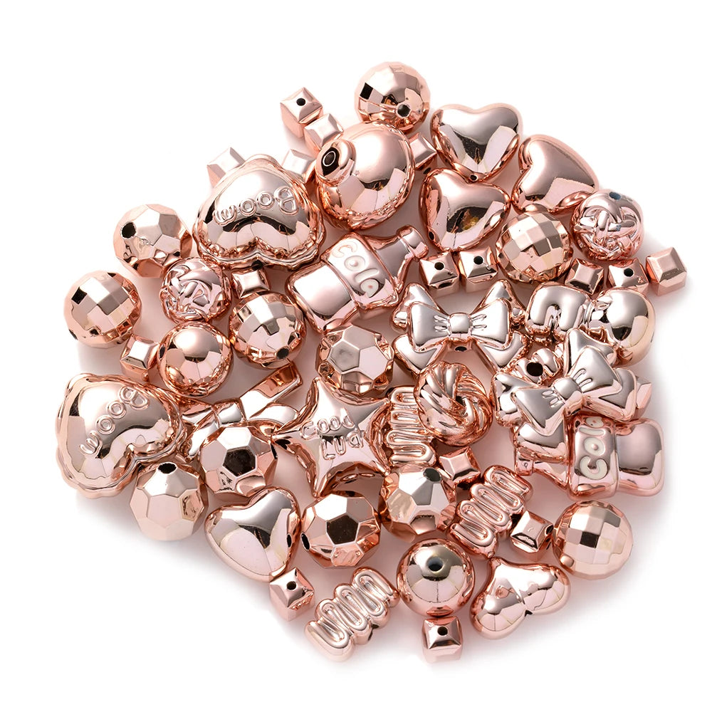 A pile of rose gold and silver-toned acrylic bow and flower beads for DIY jewelry making