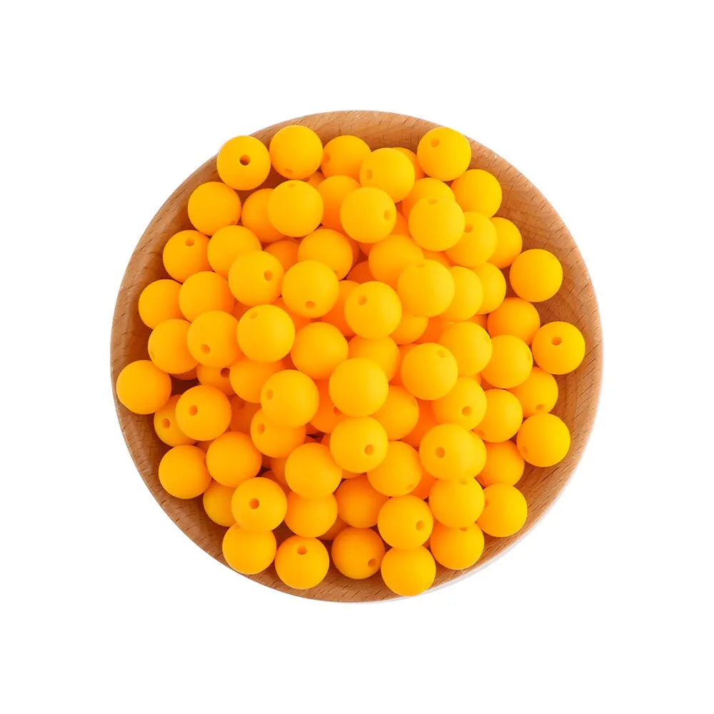 A pile of bright yellow silicone round beads for jewelry making and DIY crafts in a wooden bowl.