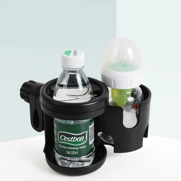 A black 2-in-1 stroller cup and phone holder with a clear glass bottle and a light green liquid.