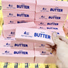 A collection of pink butter squishy blocks with blue lettering arranged in rows.