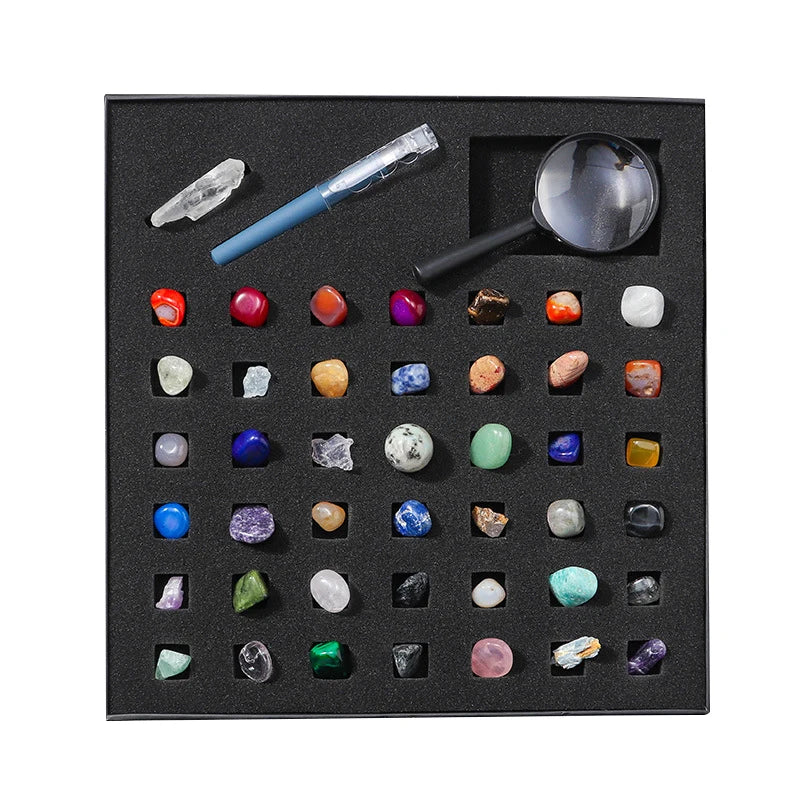 A black gift box containing a collection of various natural crystals and minerals, including quartz, amethyst, and various co