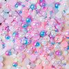 A close-up of mixed resin rhinestone pearls in various shades of pink, blue, and iridescent colors.