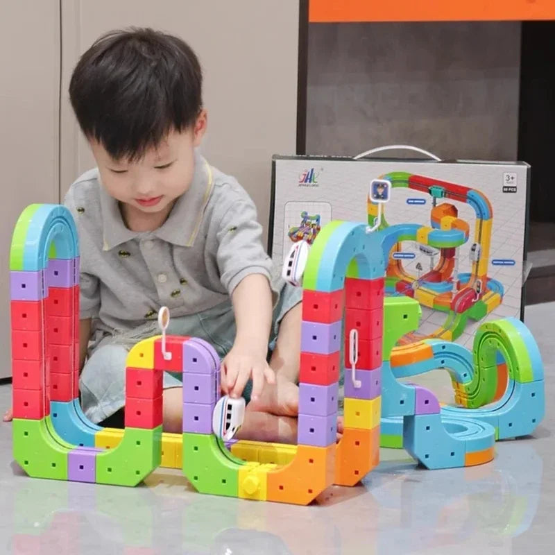 A child is interacting with a colorful DIY magnetic track train set featuring flexible rail pieces and various colored compon