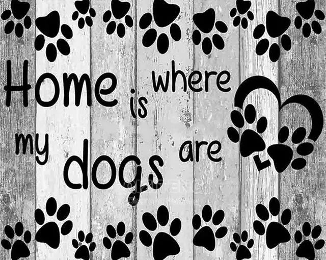 A wooden background with paw prints and the text Home is where my dogs are.