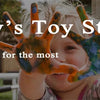 A smiling child holds out a hand painted with colorful, messy paint, demonstrating Today's Toy Store gifts.