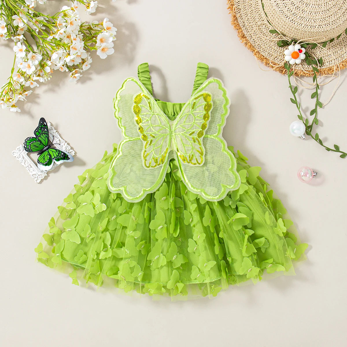 A light green tulle butterfly dress with sheer fabric wings and yellow accents, displayed on a neutral background.