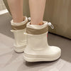 A pair of beige waterproof mid-calf rain boots with a smooth white finish and non-slip sole