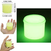 A clear plastic container of glow-in-the-dark crystal slime, emitting a bright green light.