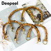 A set of natural bamboo-style bag handles with gold-colored hardware for DIY projects.