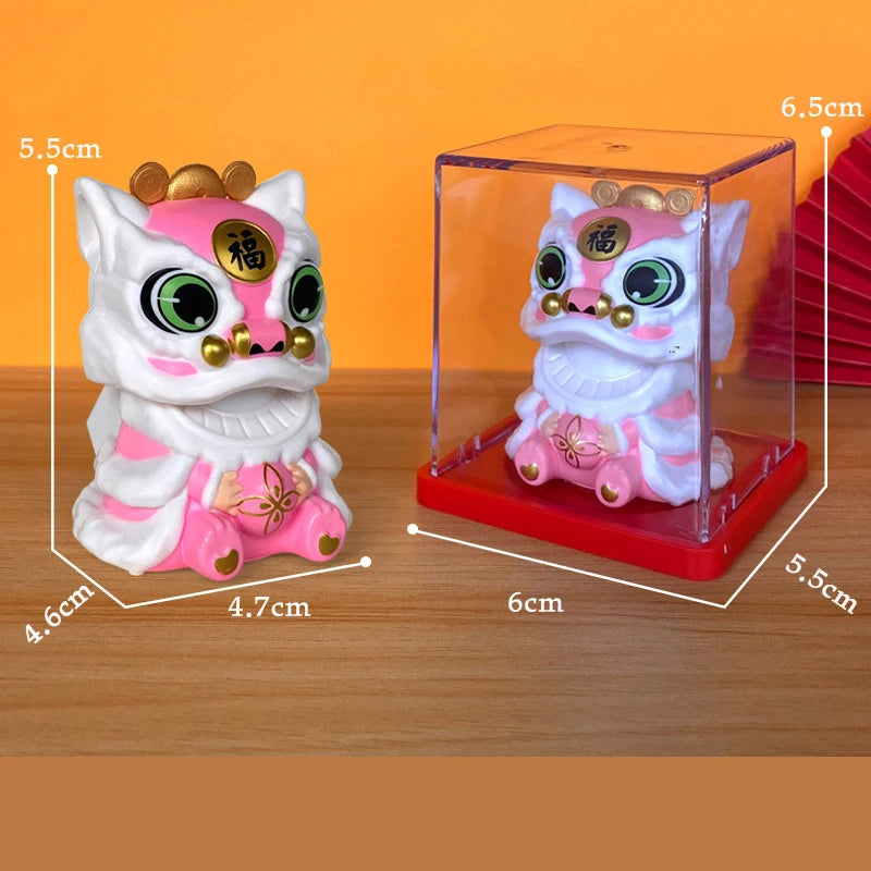 A white lion figurine with pink accents and gold details is displayed inside a clear box on a wooden surface.