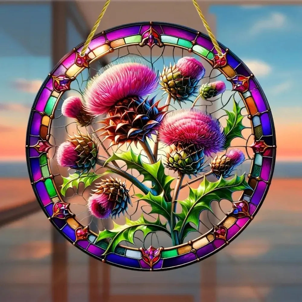 A round acrylic window hanging featuring a detailed Scottish thistle design with vibrant pink and purple flowers.