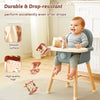 A baby is playing with a wooden mushroom castle stacking toy puzzle on a light-colored stool.