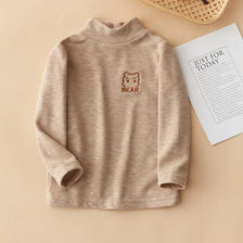 A beige long sleeve shirt for kids featuring a small brown bear embroidery on the chest.