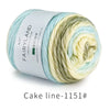 Spool of Fairyland cake ball yarn showing a gradient blend of light blue and cream colors.
