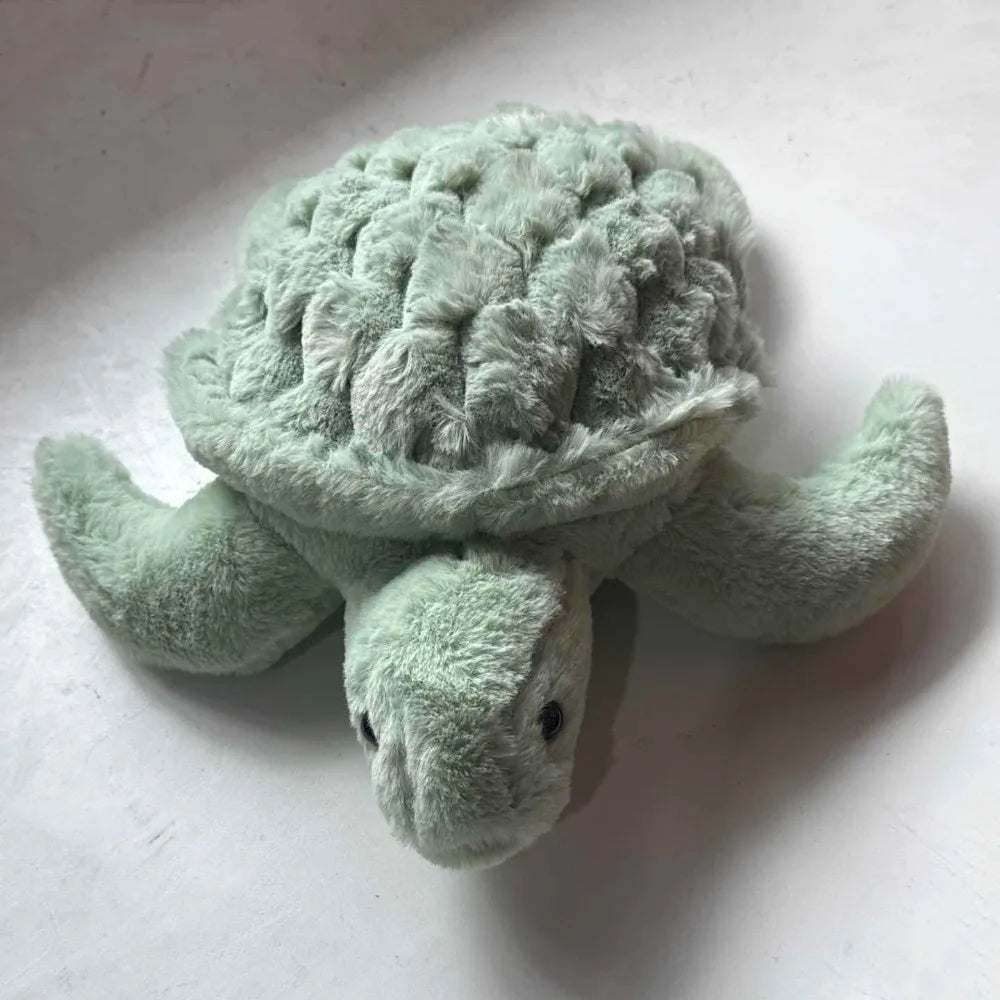 A soft, light green sea turtle plush toy with textured skin and flippers.