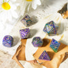A set of seven resin polyhedral dice, including a d40 and d6, displayed on a light surface next to a leather-bound notebook.