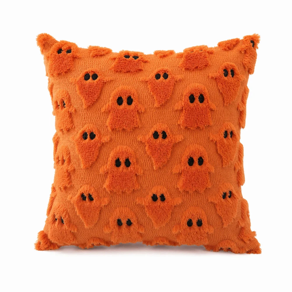 An orange, textured pillow cover featuring a pattern of small, black ghost faces.