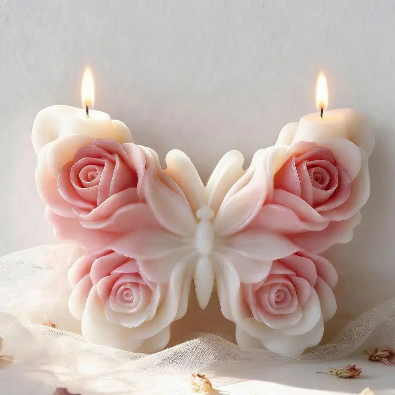 Pink and white silicone rose butterfly candle mold with a lit candle on a sheer fabric background