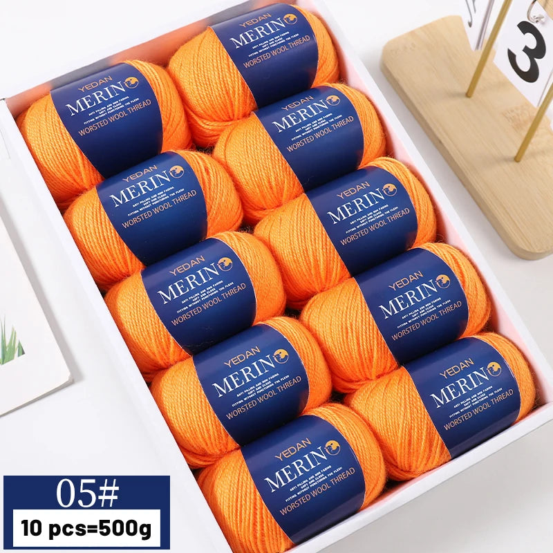 A box containing ten balls of orange merino wool yarn labeled YEDAN MERIN WORSTED WOOL THREAD