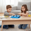 Two children play a blue strategy board game with black and white pieces on a wooden table.