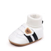 White ankle-hugging baby booties with black stripes and anti-slip soles
