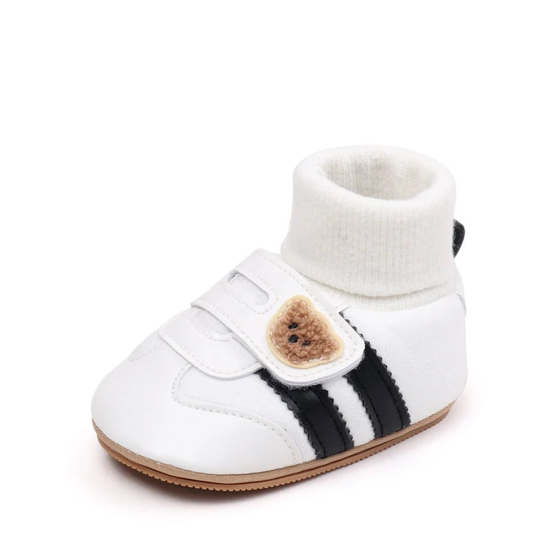 White ankle-hugging baby booties with black stripes and anti-slip soles