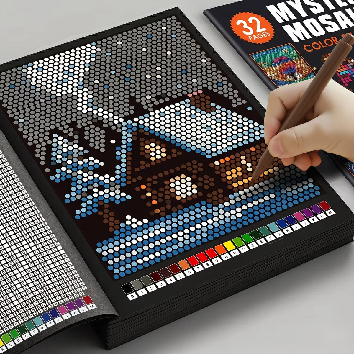 A hand is painting a mosaic art page in a book titled Mystery Mosaics Color by Number Pixel Art Book for Adults