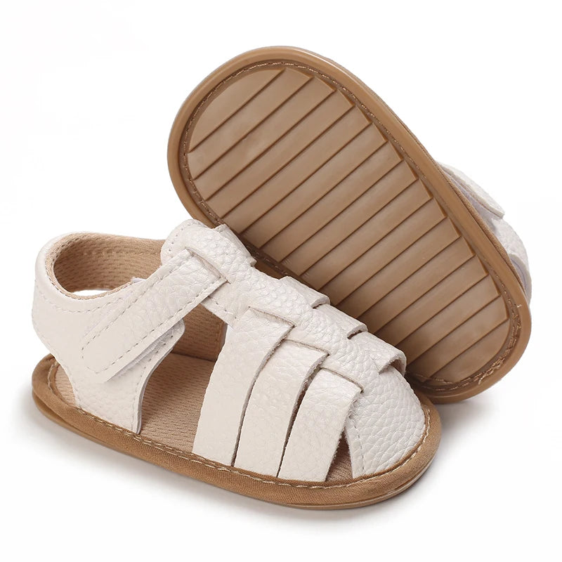A pair of beige leather baby first walker sandals with a soft anti-slip sole shown from the top.