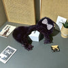A dark purple leopard print sling dress for plush dolls displayed on a gray surface.