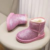 Pink glitter snow boots with faux fur lining displayed on a light-colored surface.