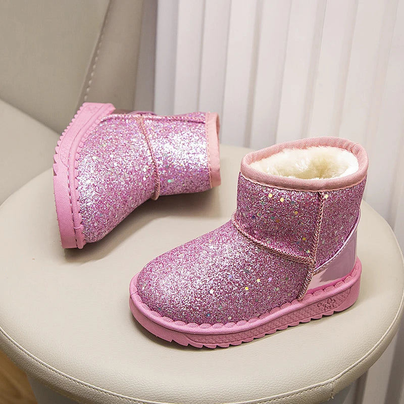 Pink glitter snow boots with faux fur lining displayed on a light-colored surface.