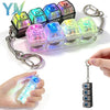 A collection of colorful LED keyboard keycap fidget flashlights are displayed, with one being attached to a keychain.