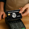 A hand holds a Mexican Express card skin sticker set featuring a sombrero design on a black background.