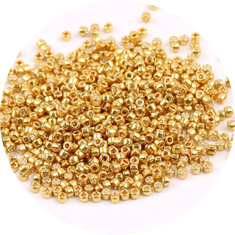 A pile of small, round metallic gold glass beads for jewelry making