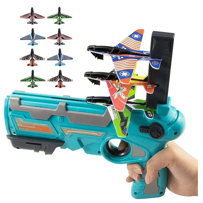 A toy airplane launcher gun is shown with three foam planes attached, being held by a hand.